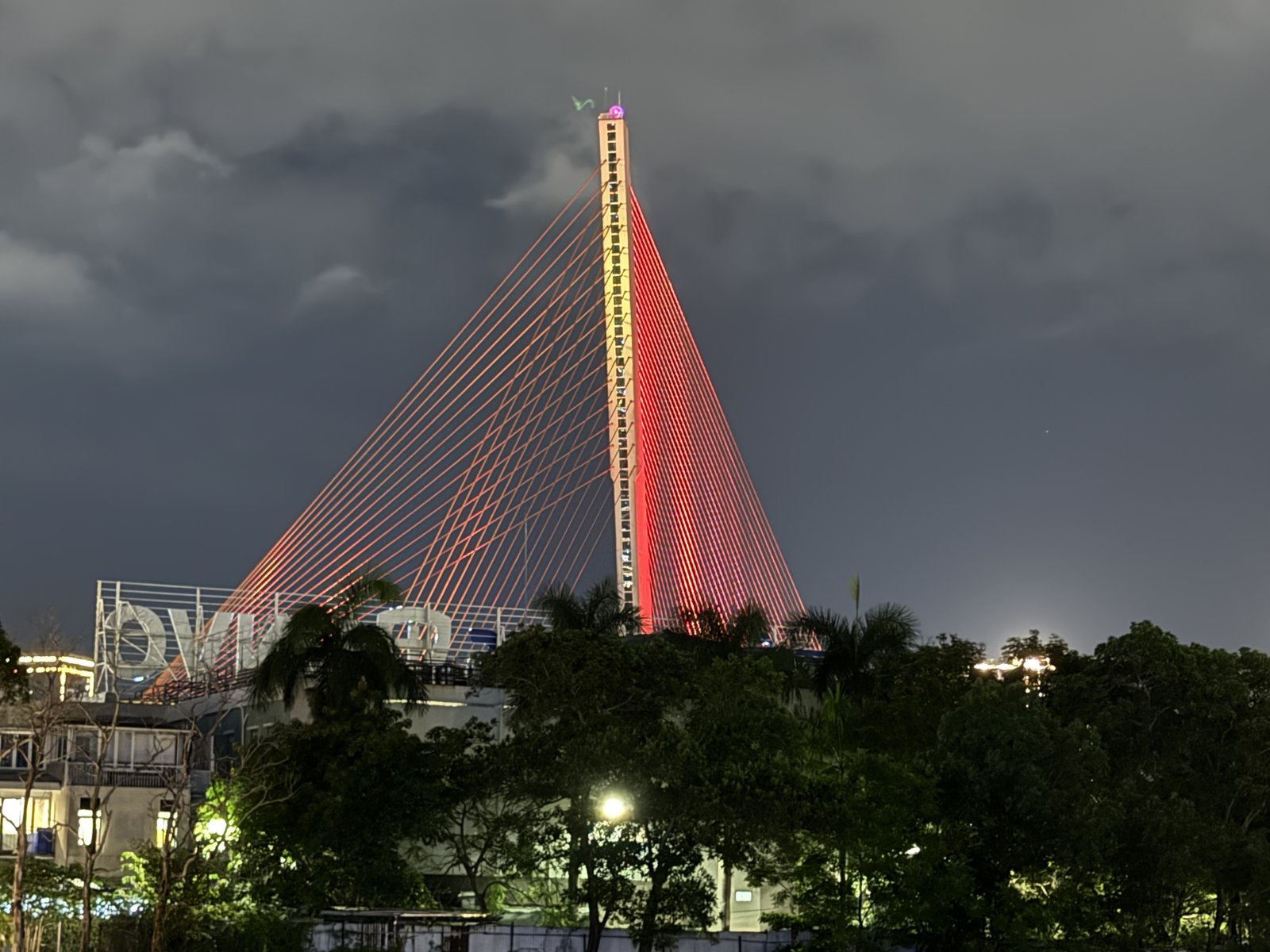 The Trần Thị Lý tower, lit red against the clouds.
