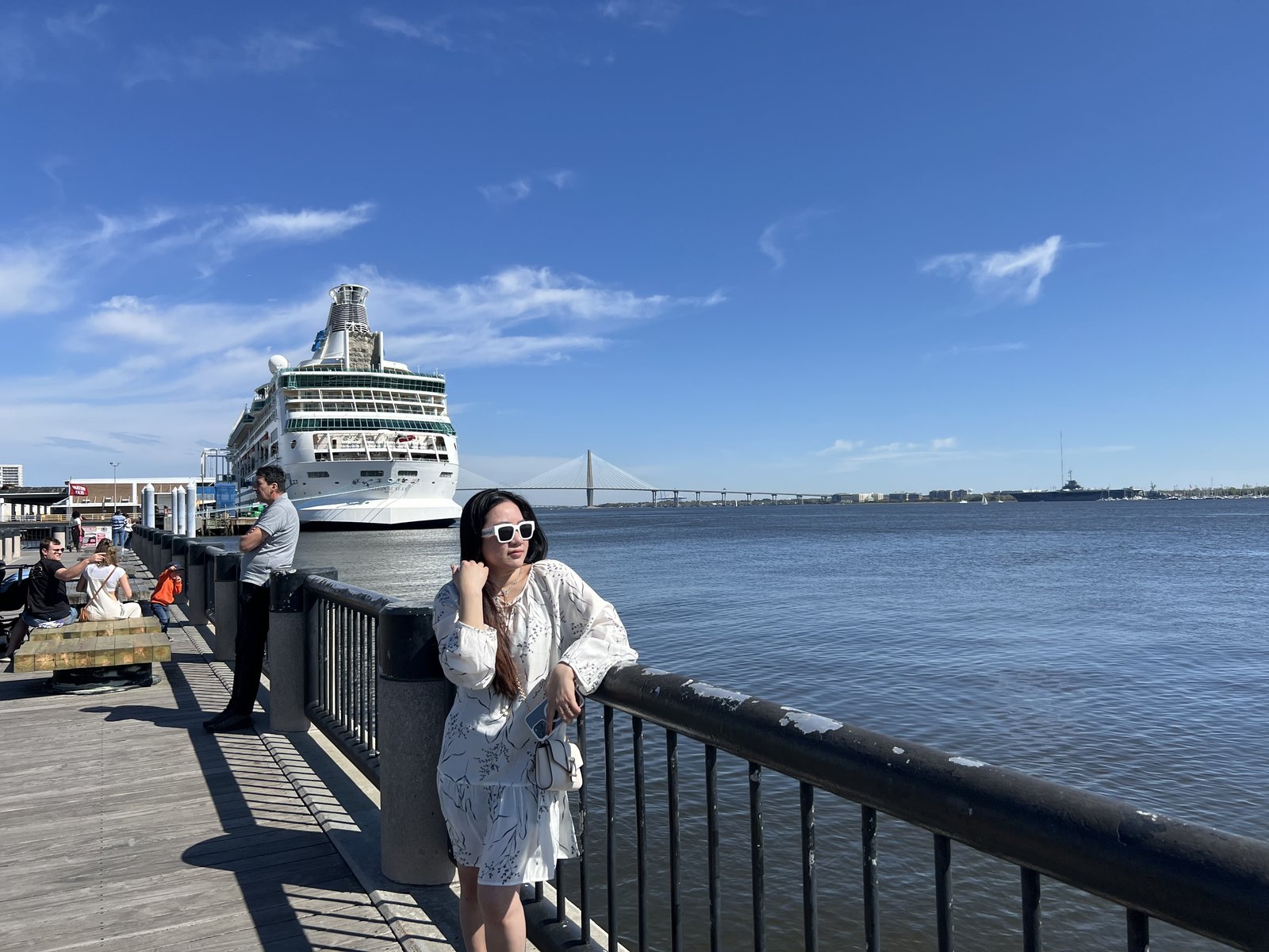 Diem on the harbor walk, a cruise ship at the dock and the Ravenel Bridge behind.