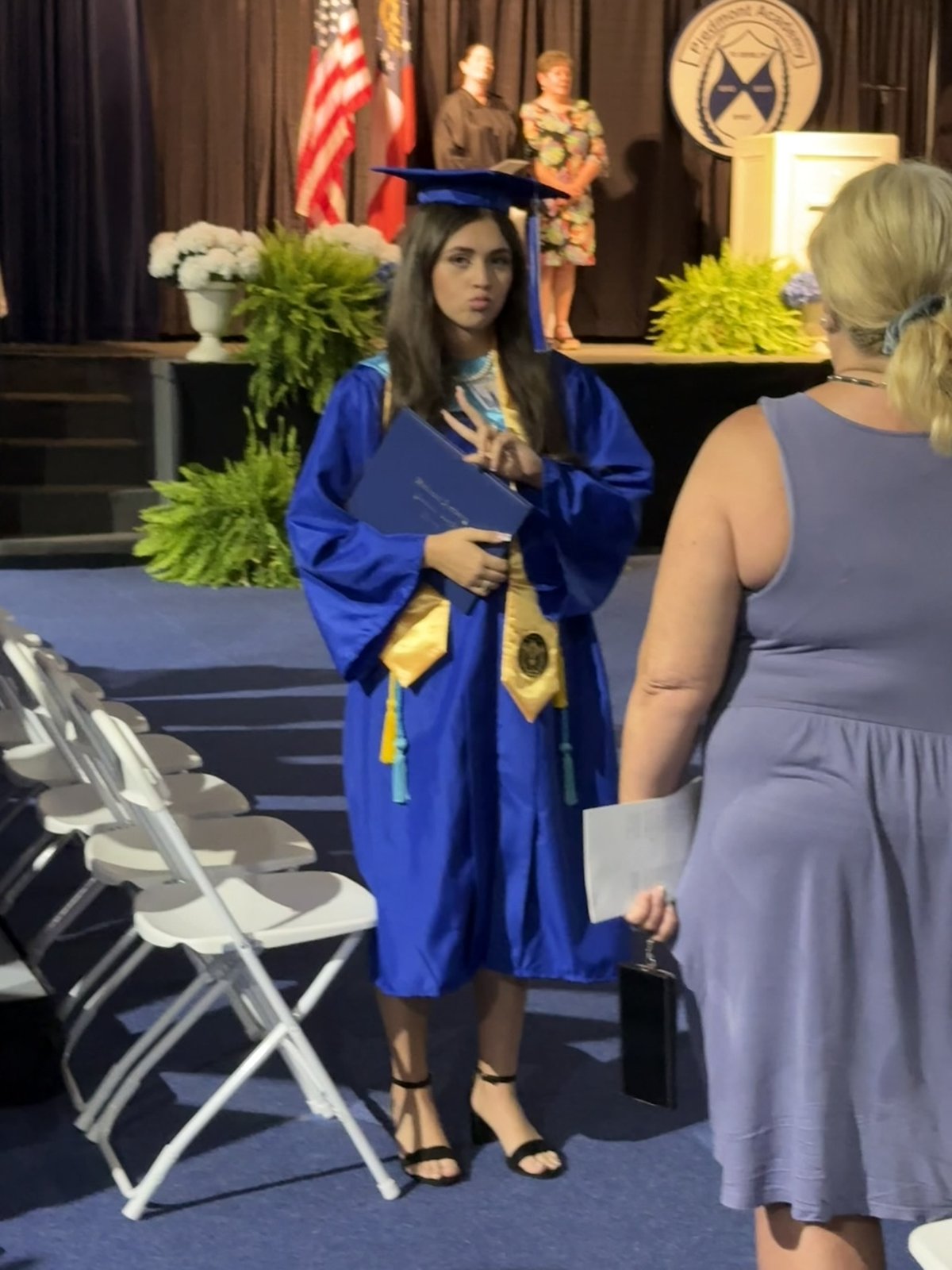 Maggie, hand on her heart, on graduation day.