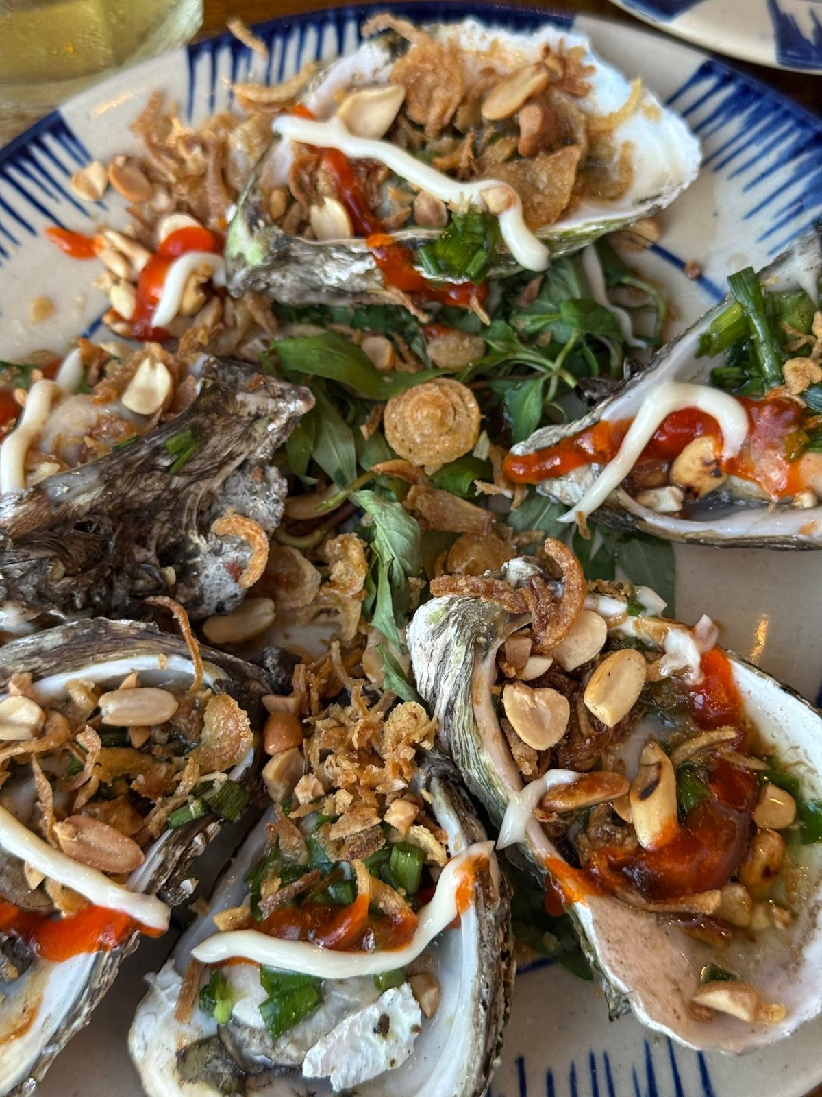 Grilled oysters, with peanuts, fried shallots and sauce.